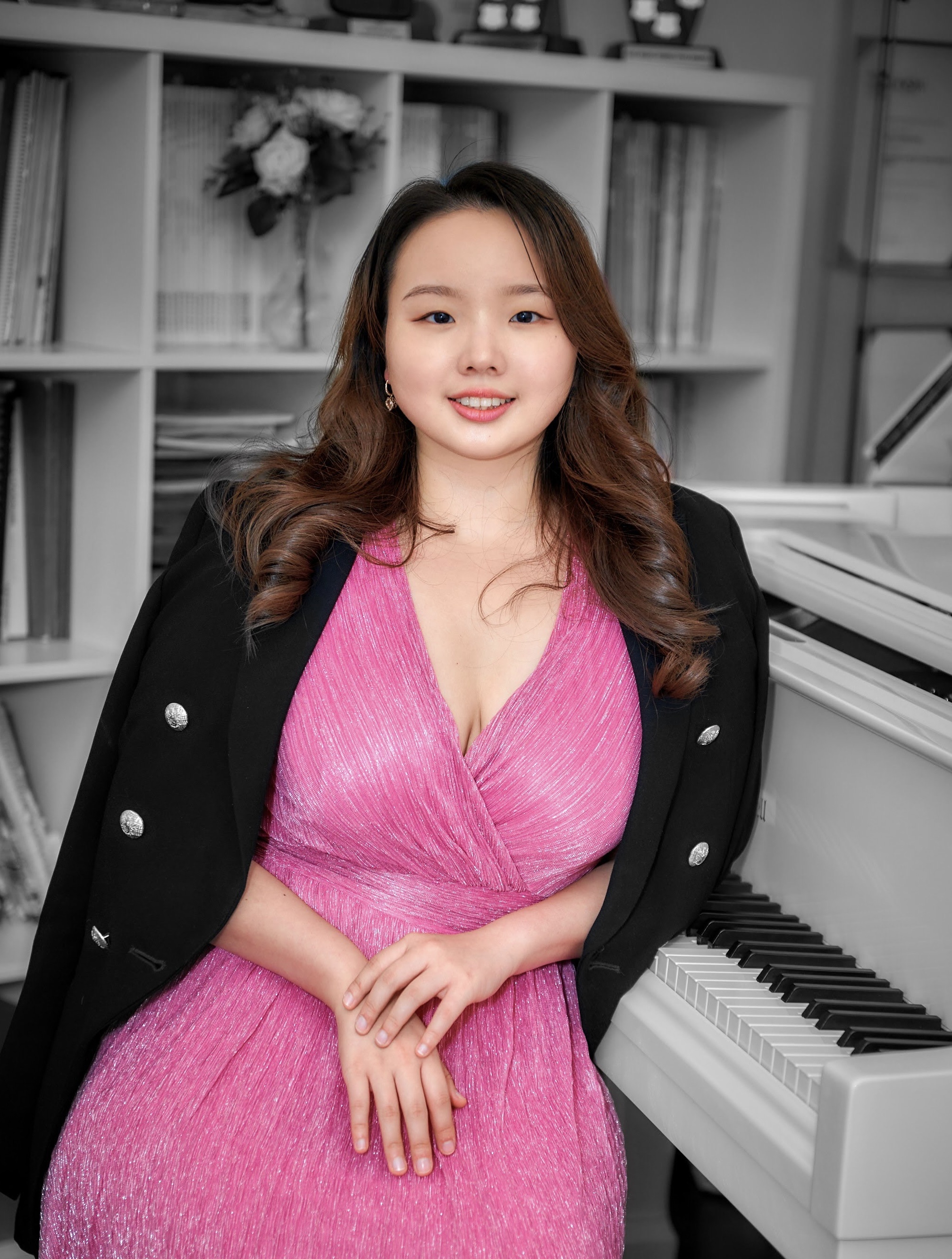 girl in pink dress sitting by the piano