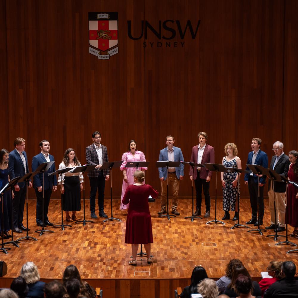 chamber choir on stage with conductor